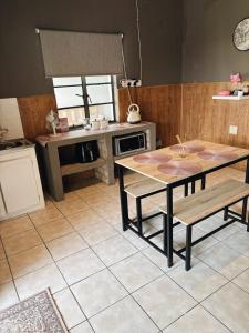 a kitchen with a table and a table and chairs at Farm Apartment in Stampriet