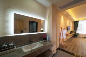 un bagno con lavandino e specchio di Lansheng Lucky Light Luxury Smart B&B a Lijiang