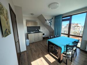 a kitchen and dining room with a blue table and chairs at Guest house Sineva in Primorsko