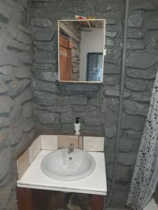a bathroom with a sink and a stone wall at Chalet 4 at Cynthias Country in Hartbeespoort