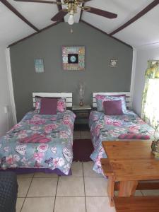 a bedroom with two beds and a wooden table at Chalet 4 at Cynthias Country in Hartbeespoort