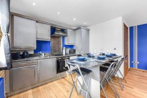 a kitchen with a table with blue dishes on it at Zone 1, Family Friendly, 2 Beds, Central London in London +6 photos