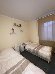 a bedroom with two beds and a window in it at Biała Dama in Łomża +12 photos
