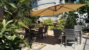 a table and chairs and an umbrella on a patio at Guest house Sineva in Primorsko
