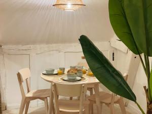 a dining room with a table and chairs and a plant at La Suite Beldi Crush, Cosy & Hypercenter in Beauvais