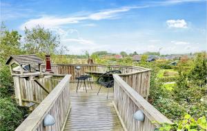 a wooden walkway with a table and chairs on it at Cozy Log Cabin With A Panoramic View in Glesborg