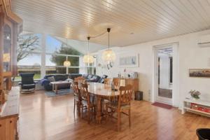 a kitchen and living room with a table and chairs at Lovely Holiday Home By The Limfjord in Storvorde +18 photos