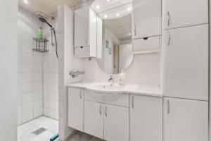 a white bathroom with a sink and a mirror at Lovely Holiday Home By The Limfjord in Storvorde
