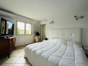 een slaapkamer met een groot wit bed en een bureau bij Villa proche du centre-ville de Porto-vecchio et de ses plus belles plages in Porto-Vecchio
