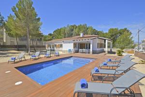 a swimming pool with lounge chairs next to a house at House PINOCHA in Can Picafort