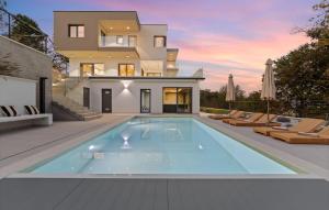 une piscine devant une maison dans l'établissement Cozy Home In Icici With Sauna, à Ičići 17 autres photos