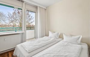 two beds in a white room with a window at 1 Bedroom Gorgeous Apartment In Anklam in Anklam +13 photos