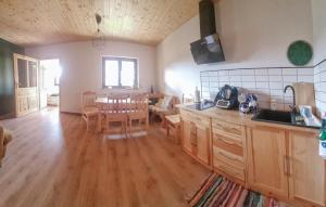 a kitchen and dining room with a table and chairs at 3 Bedroom Awesome Home In Barwald Dolny in Barwałd Dolny