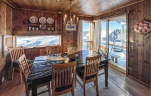 a dining room with a table and chairs and a window at Cozy Home In Sjusjøen With Sauna in Sjusjøen