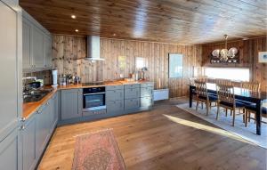a kitchen with wooden walls and a table with chairs at Cozy Home In Sjusjøen With Sauna in Sjusjøen
