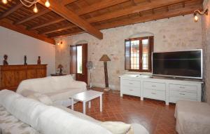 a living room with white furniture and a flat screen tv at Nice Home In Noto With Wifi in Noto