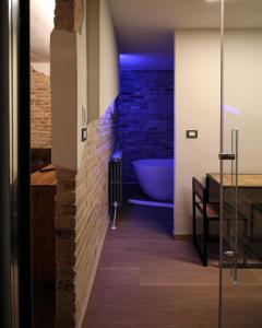 a bathroom with a brick wall and a bath tub at INsideOUT RELAX in Porto SantʼElpidio +14 photos
