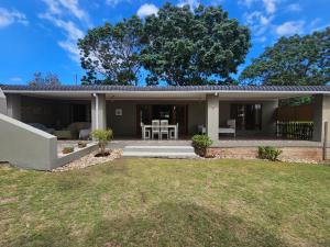 a house with a patio and a yard at GUINEA FOWL in Plettenberg Bay