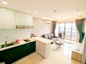 a kitchen with a sink and a couch in a room at Lovina 13-19 at Harbour Bay Residence in Tanjunguma