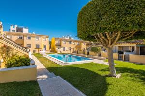 een zwembad in een tuin met een boom bij Casa Fre - Lomas Del Golf - Villamartin in Villamartin