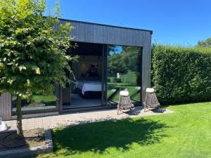 a glass house with two chairs in a garden at Attefallshus svit Dunö in Kalmar