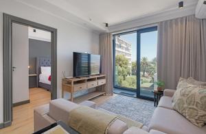 Una sala de estar con un sofá y un televisor. en The Portswood by Stay In Luxury, en Ciudad del Cabo