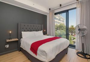 Un dormitorio con una cama grande y una ventana grande. en The Portswood by Stay In Luxury, en Ciudad del Cabo
