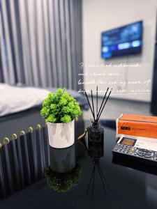 Gia Lâm PhoにあるSTUDIO 1BR, 1 giường Toà Ruby Vinhomes Ocean Parkの花瓶とカメラテーブル