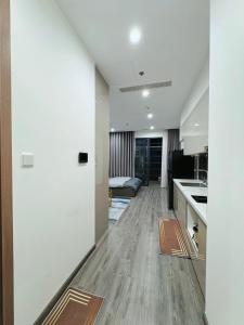Gia Lâm PhoにあるSTUDIO 1BR, 1 giường Toà Ruby Vinhomes Ocean Parkの白い壁とウッドフロアのキッチン