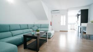 a living room with a blue couch and a table at Flat 'Hoces del Cabriel' in Casas de Moya in Casas de Moya