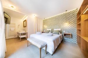 a bedroom with a bed and a desk and a sink at Les Capucines Saint Tropez in Saint-Tropez