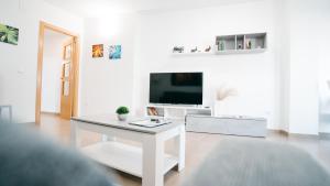 a white living room with a white table and a tv at Cuchillos de la fonseca in Casas de Moya