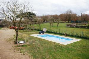 a small swimming pool in a field with a tree at La Molinera Casa Rural - Ribeira Sacra in Campo