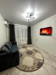 a living room with a couch and a fireplace at 2х комнатная квартира с кодовым замком in Uralsk