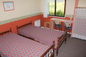Un dormitorio con dos camas y una mesa y sillas. en Villa du Bac, en Chambon-sur-Lac