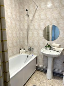 a bathroom with a tub and a sink and a mirror at 2х комнатная квартира с кодовым замком in Uralsk