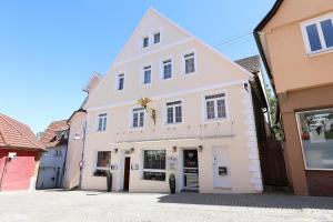 a white building on the side of a street at Hotel Adler in Waiblingen