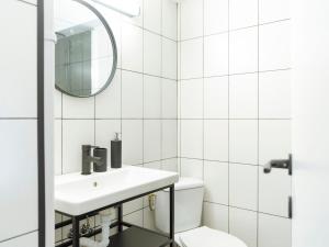 une salle de bain blanche avec un lavabo et un miroir dans l'établissement Aura - Old Town, à Bucarest 25 autres photos
