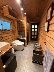 a wooden bathroom with a toilet and a sink at Rental villa Gontaya in Takamori