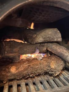a grill with two pieces of wood and fire at Rental villa Gontaya in Takamori