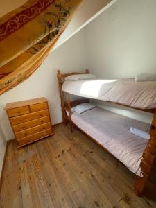 two bunk beds in a room with a wooden floor at joli T3 au coeur de lourdes in Lourdes