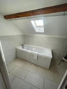 a bathroom with a bath tub with a window at joli T3 au coeur de lourdes in Lourdes