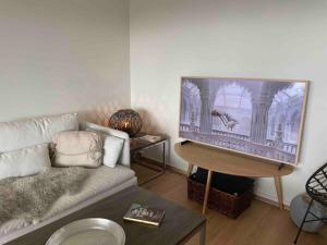 a living room with a couch and a large tv at Waterfront apartment in Risør