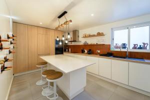 a kitchen with white cabinets and a counter and stools at Casa de Maiorca in Maiorca