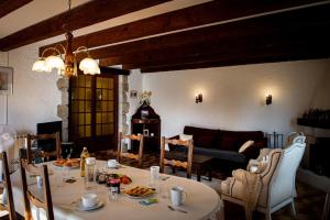 a dining room with a table and chairs and a couch at "Chez Jean" à Ruoms in Ruoms