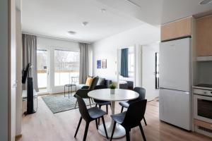 a kitchen and living room with a table and chairs at Hiisi Homes Kirkkonummi Masala Salmipolku in Masala +24 photos