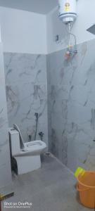 a bathroom with a toilet and a stone wall at Shree dham home stay in Faizābād