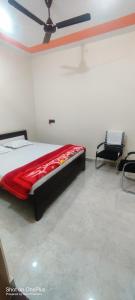 a bedroom with a bed and two chairs in it at Shree dham home stay in Faizābād +2 photos