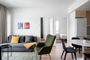 a living room with a couch and a table at Hiisi Homes Kirkkonummi Masala Salmipolku in Masala