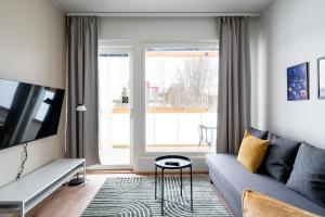 a living room with a couch and a tv at Hiisi Homes Kirkkonummi Masala Salmipolku in Masala